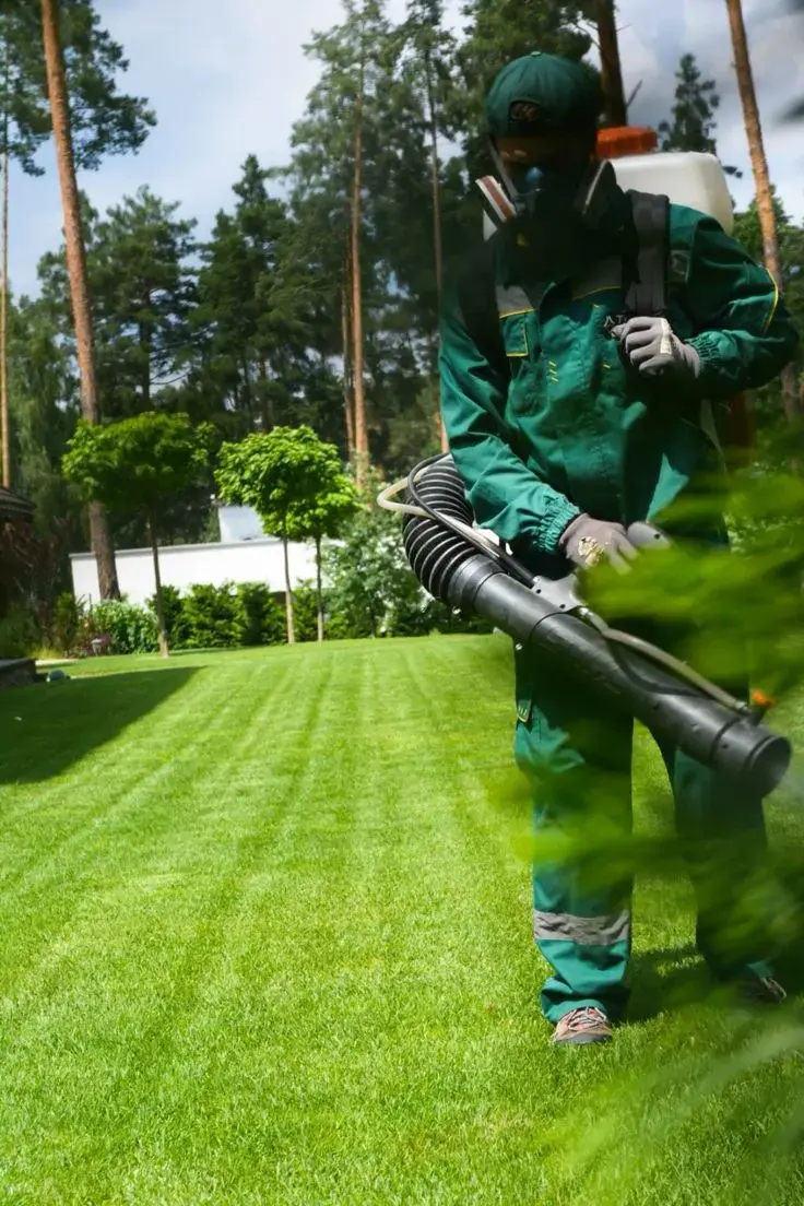 KIC-BUG technician performing pest control treatment at a client property